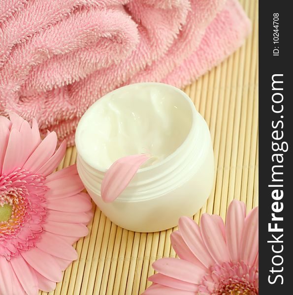 Spa essentials. Bowl of cream, pink towel and flowers. Spa essentials. Bowl of cream, pink towel and flowers.