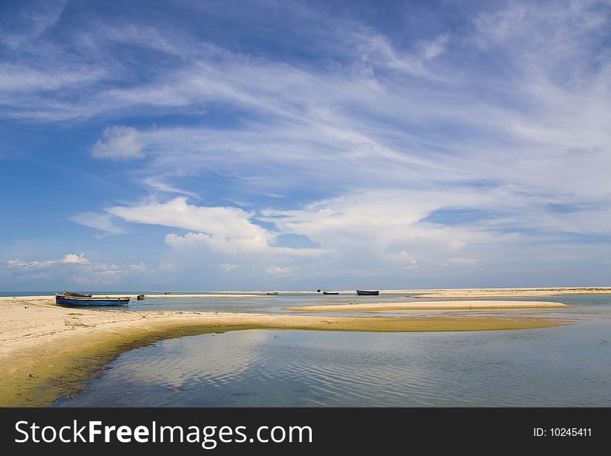 Blue sky, white clouds, boats on sandbanks, spits in a sea. Blue sky, white clouds, boats on sandbanks, spits in a sea