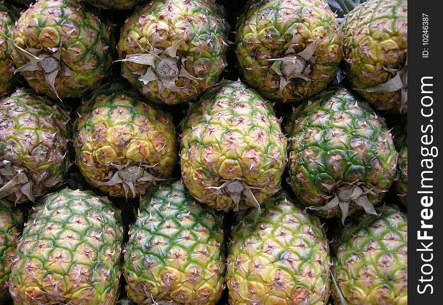 Stock photo of a stack of pineapples in a marketplace