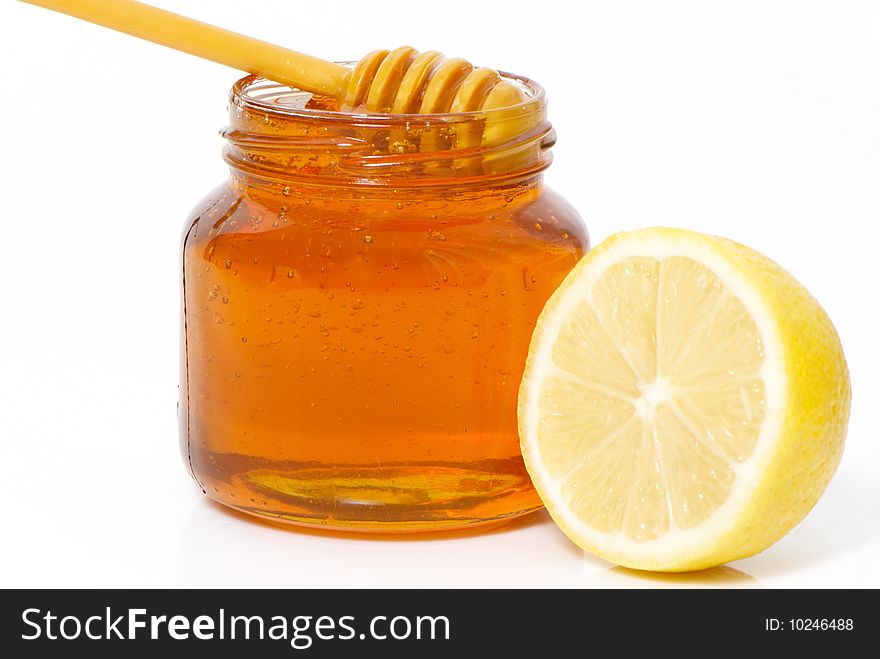 Honey jar and lemon isolated on white background