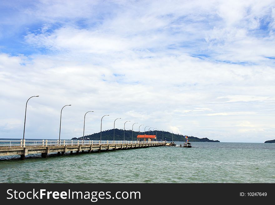 Landscape view of jetty on cloudy sunny day.