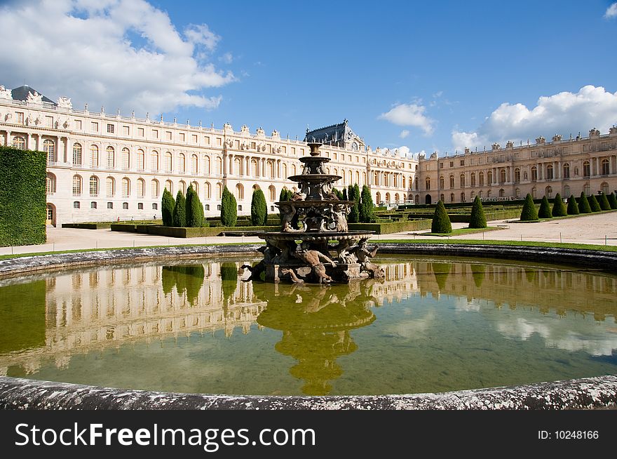 Classic fountain in paris royal park with water reflection