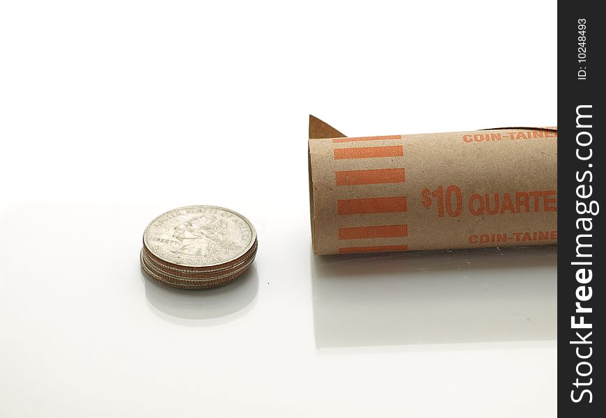 A stack of quarters outside an open quarter roll on a white bg. A stack of quarters outside an open quarter roll on a white bg.