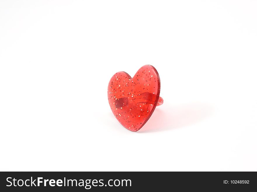 A childs heart shaped ring on a white background.