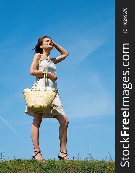 Beauty woman with bag stand on green grass