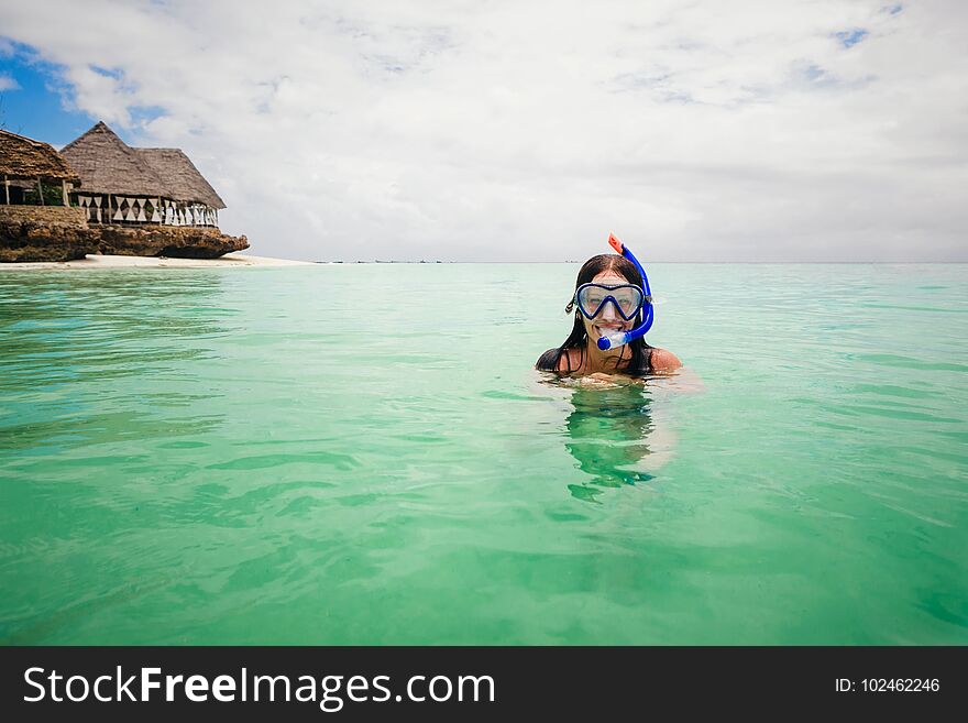 Happy woman wearing mask for snorkeling in the turquoise ocean