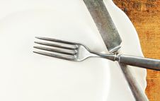 White Plate And Silverware Wooden Table Royalty Free Stock Image