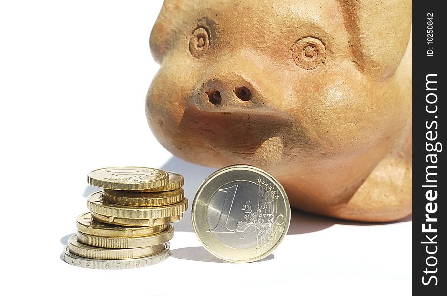 Stack of Euro coins in front of terracotta piggy bank. Stack of Euro coins in front of terracotta piggy bank