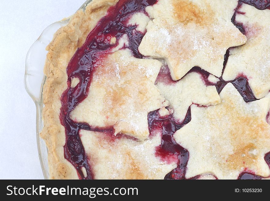 A warm fresh raspberry pie cools on the counter