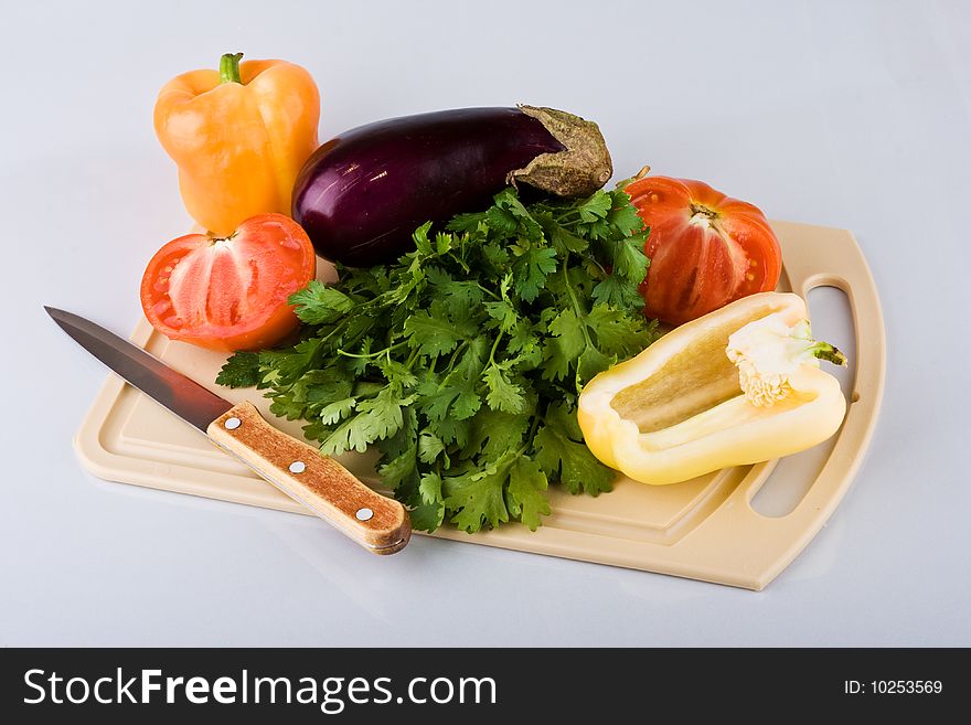 Vegetables on chopping board on light background