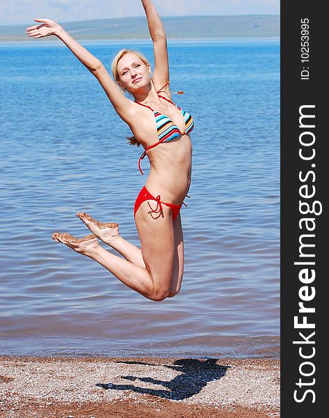 HAPPY YOUNG BEAUTIFUL WOMAN JUMP ON THE BEACH. HAPPY YOUNG BEAUTIFUL WOMAN JUMP ON THE BEACH