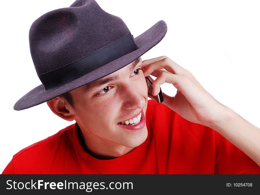 Young man with red shirt and black hat speaking on phone