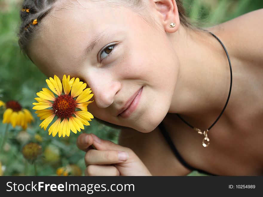 Portrait of nice young girl handing yellow flower near her face. Portrait of nice young girl handing yellow flower near her face