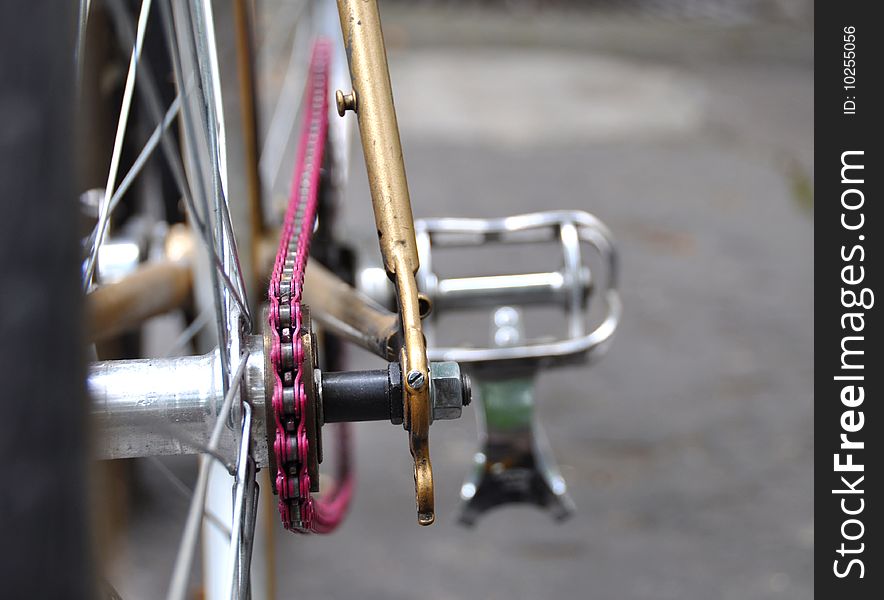A vintage bicycle with a pink chain