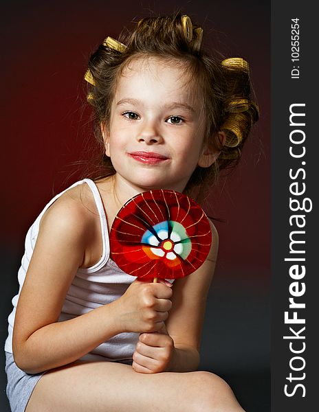 Portrait of little curly girl with lollipop