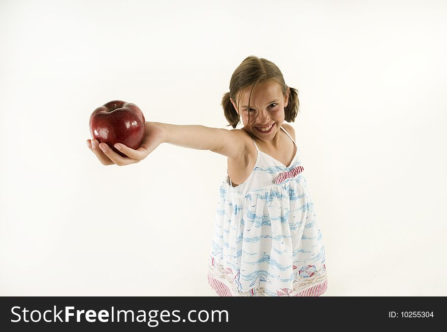 A young girl holding out an apple isolated on white. A young girl holding out an apple isolated on white