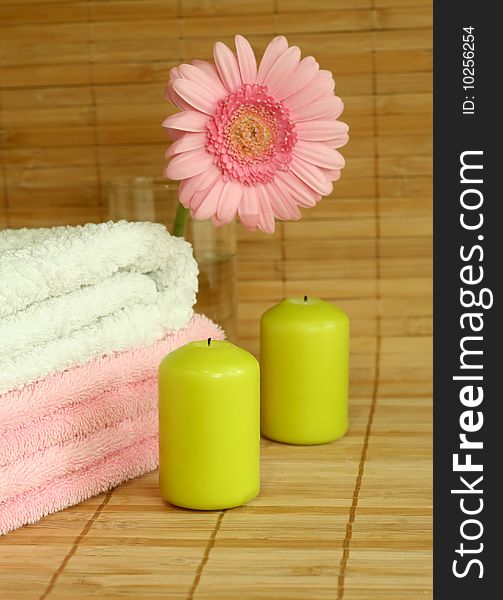 Spa concept. Towels, candles and pink gerber.
