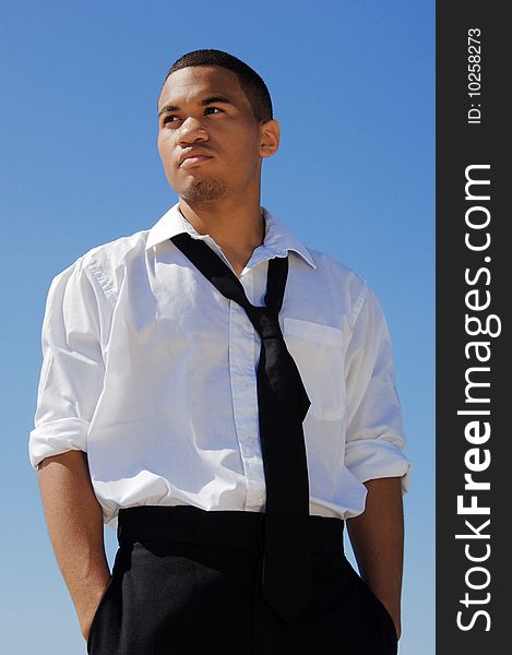 Young man in a white shirt and black tie against the blue sky. Young man in a white shirt and black tie against the blue sky.