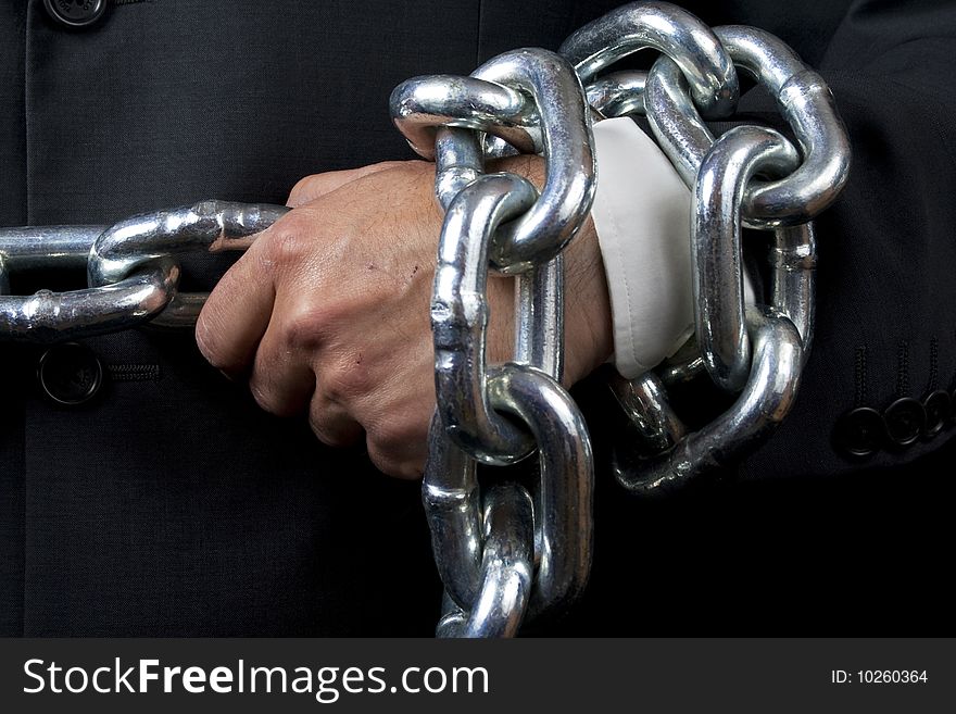 Businessman holding a heavy chain, isolated on black. Businessman holding a heavy chain, isolated on black