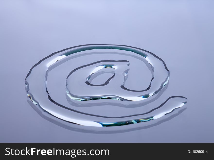 At symbol written in water on a glass plate