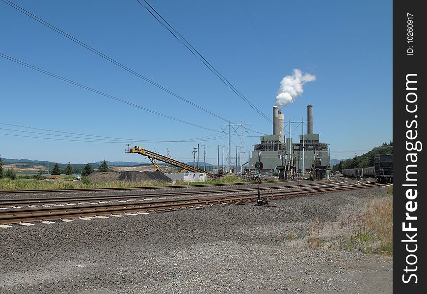 A modern two boiler coal fired powerplant in operation. Railroad tracks in the foreground are for the trains that provide this plant with thousands of tons of coal. A modern two boiler coal fired powerplant in operation. Railroad tracks in the foreground are for the trains that provide this plant with thousands of tons of coal.