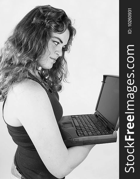 A black and white photo of an young woman holding an laptop in her hand and is concentrated on the screen, with long curly hair. A black and white photo of an young woman holding an laptop in her hand and is concentrated on the screen, with long curly hair.