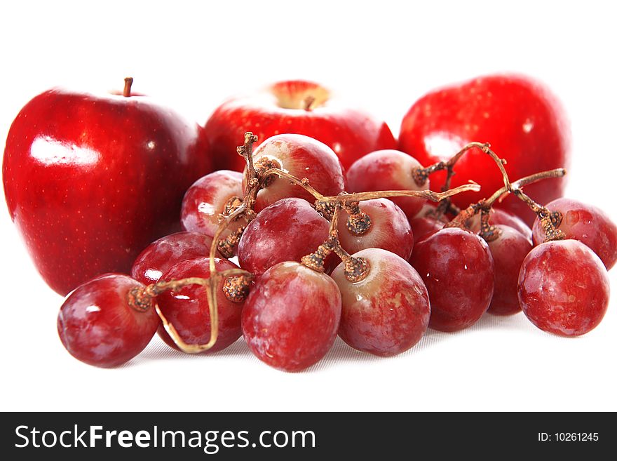 Fresh red grape and apples isolated on white