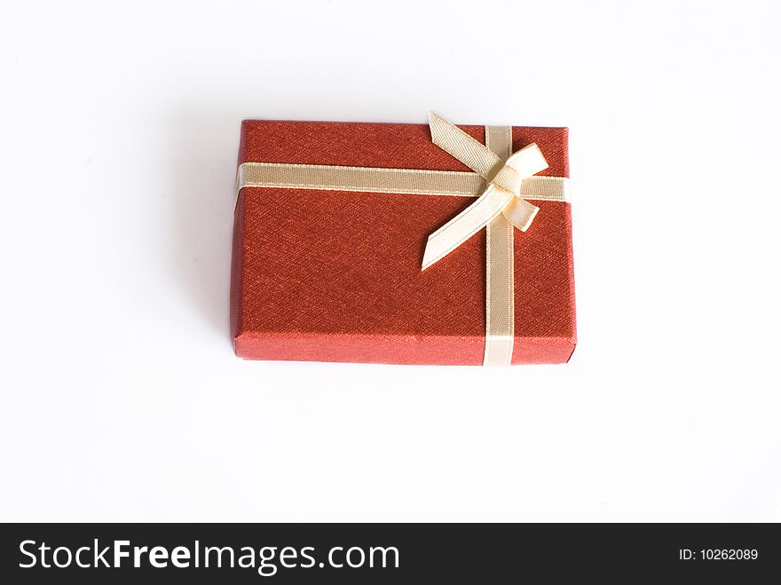 Red gift with pink cream ribbon on isolated white background