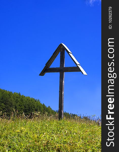 Wooden crucifix in the meadow