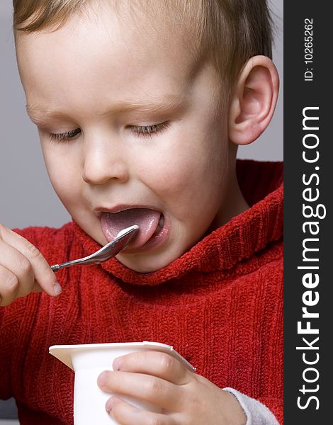 Little Boy eating yogurt or yoghurt