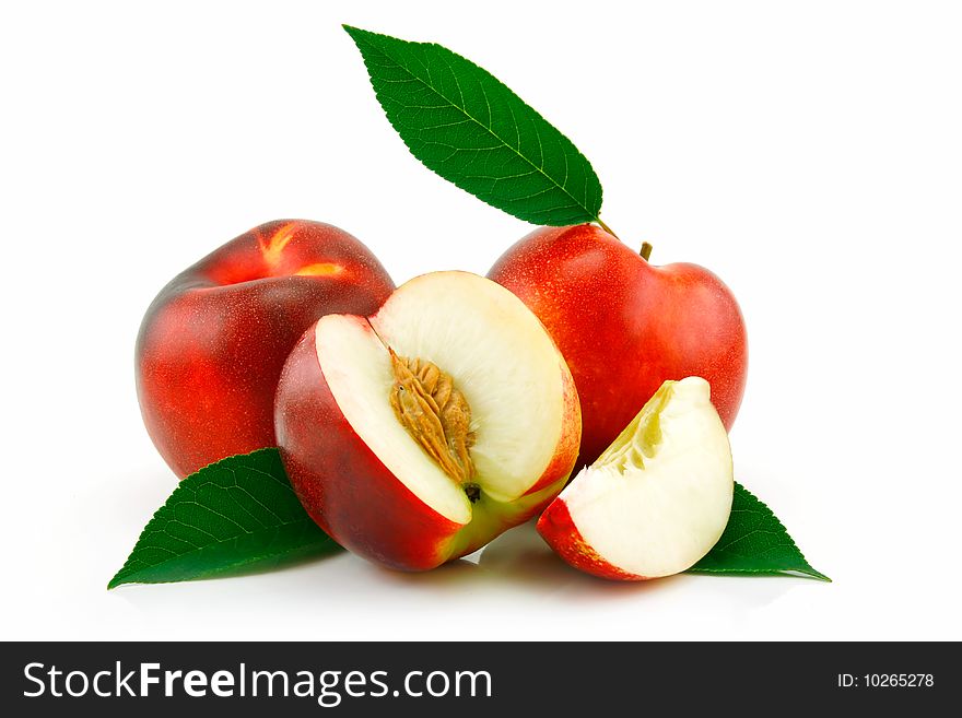 Ripe sliced peach (Nectarine) with green leafs isolated on white background