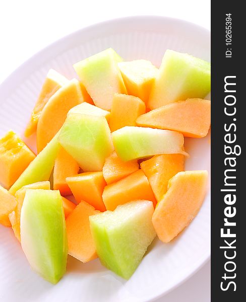 Juicy sliced melon on plate, isolated on white background.