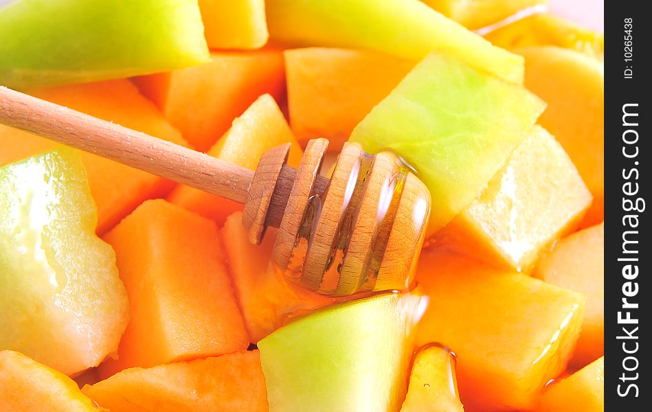 Juicy sliced melon on plate with honey