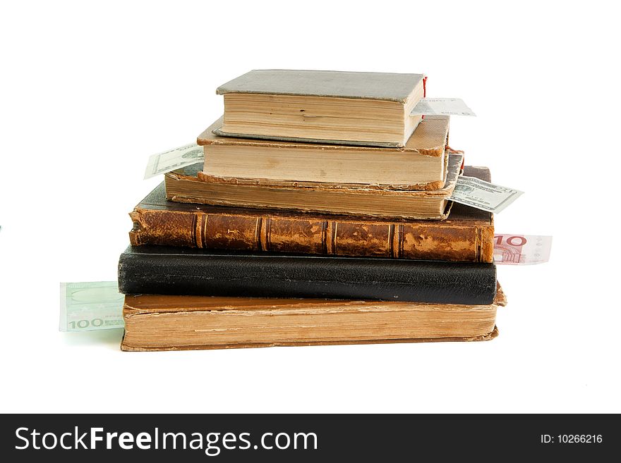 Stack of old books with banknote bookmarks isolated on white