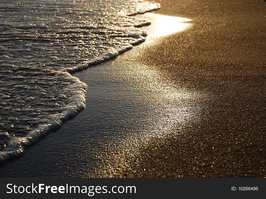 Sandy beach and sea waves during sunset. Sandy beach and sea waves during sunset