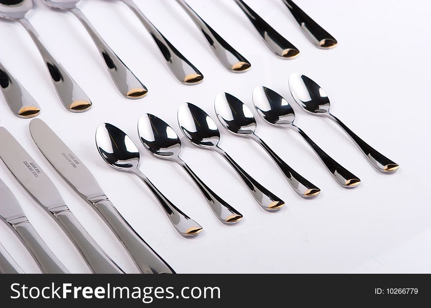 Row of spoons and forks on a white background