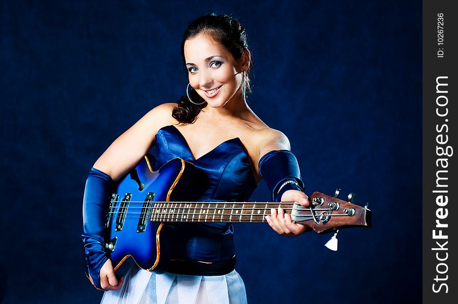 Portrait of a young brunette woman playing the guitar. Portrait of a young brunette woman playing the guitar