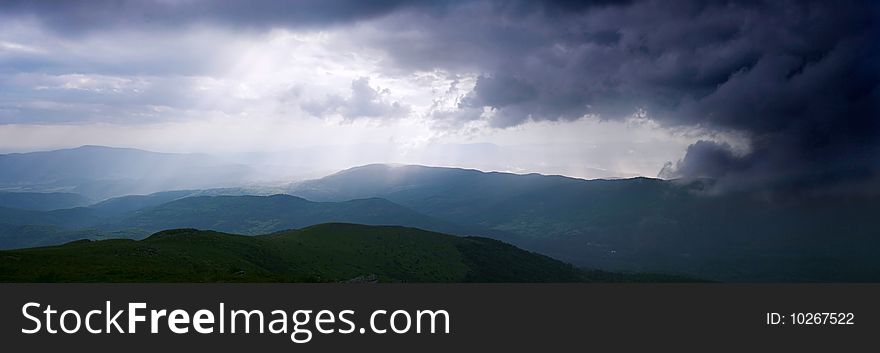 Sun rays through the cloudy sky. Carpathian Mountains