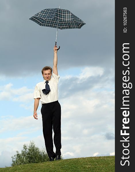 Businessman holding umbrella over head in a city park. Businessman holding umbrella over head in a city park