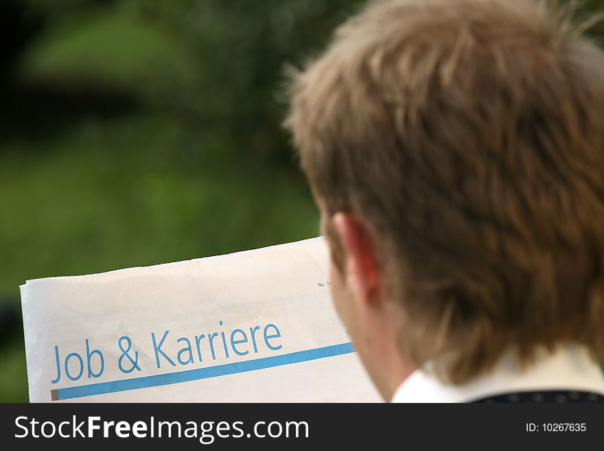 Man reading newspaper with job and career