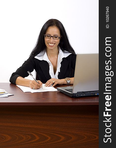 Attractive businesswoman at her desk signing papers