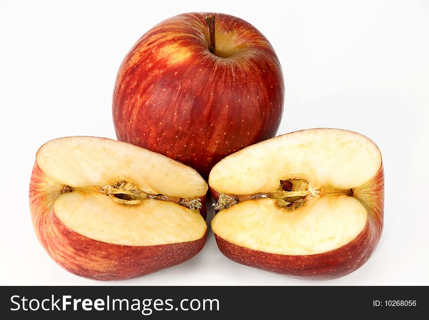Two red apples, whole and cut on a white background