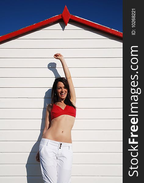 happy woman standing outside beach hut