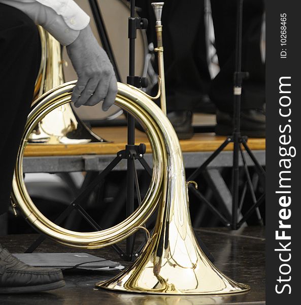 This is a shiny french horn held by an orchestra member in france