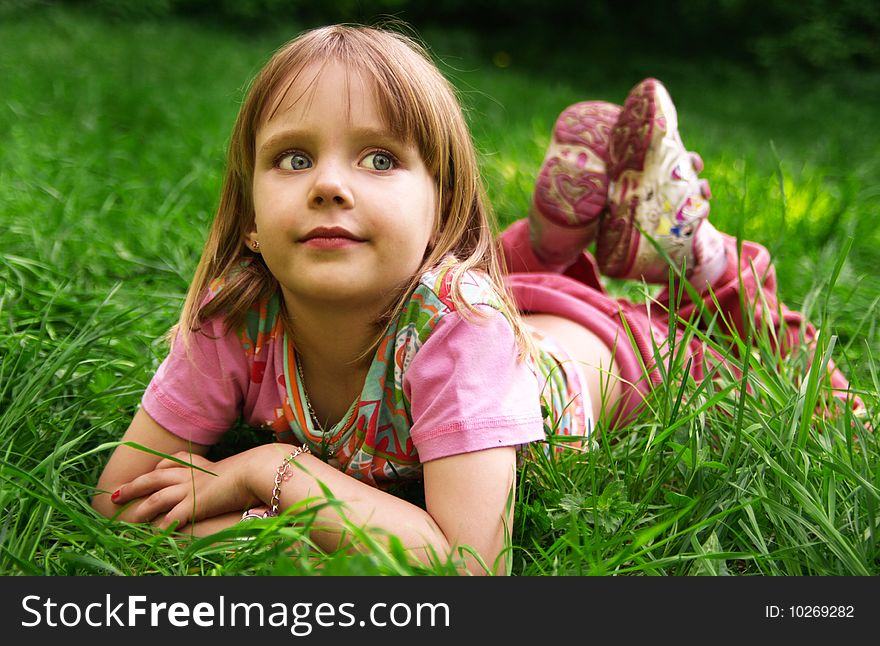 Little girl lying on grass. Little girl lying on grass