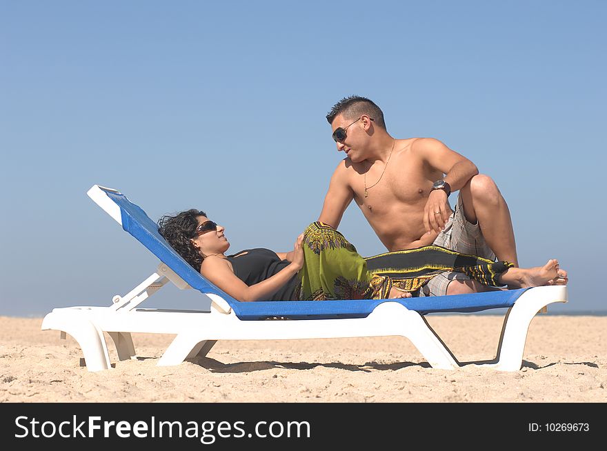 Attractive lovely couple relaxing on the beach. Attractive lovely couple relaxing on the beach