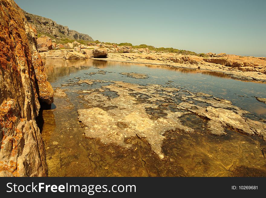 Tidal rockpool in the West Coast, South Africa, with mountains in background