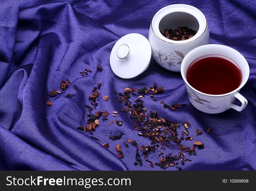 A cup of red tea beside the tea dispenser