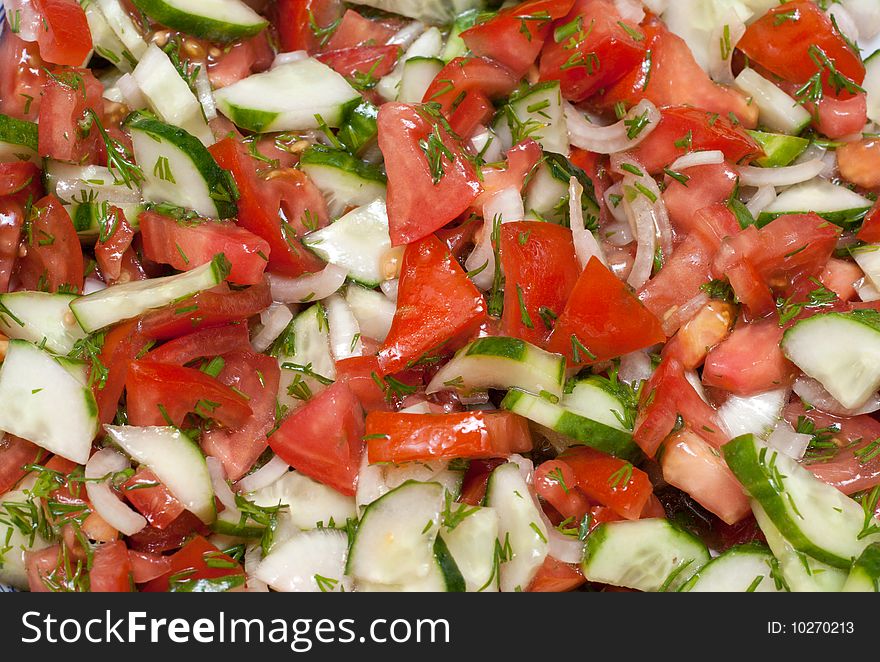 Appetizing salad from fresh tomato and cucumber in olive oil