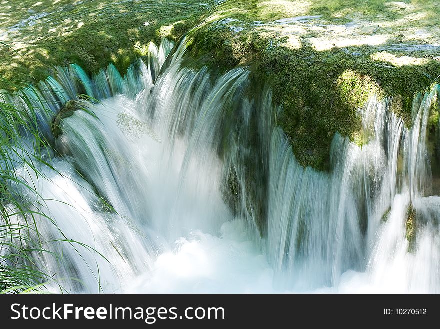 Small waterfall in in mountains as background